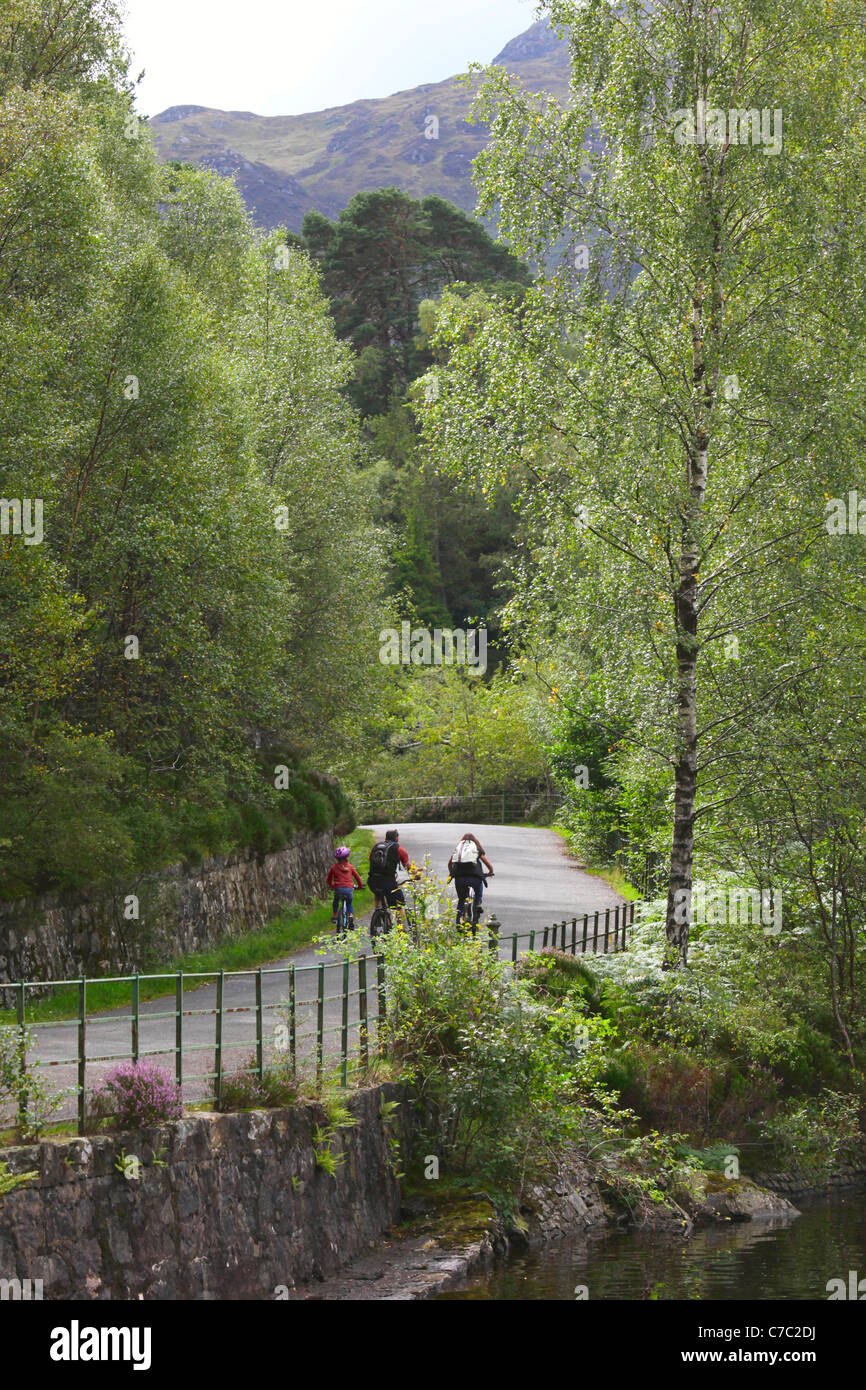 Tres ciclistas junto a Loch Katrine en los Trossachs Escocia Foto de stock