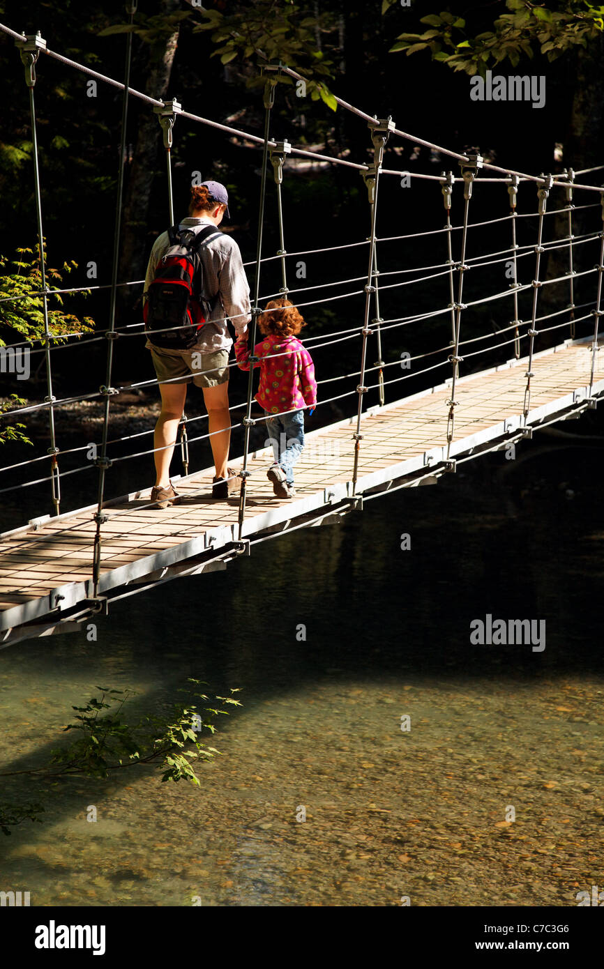 Madre e hija cruzando un puente colgante, Ohanapecosh River, la