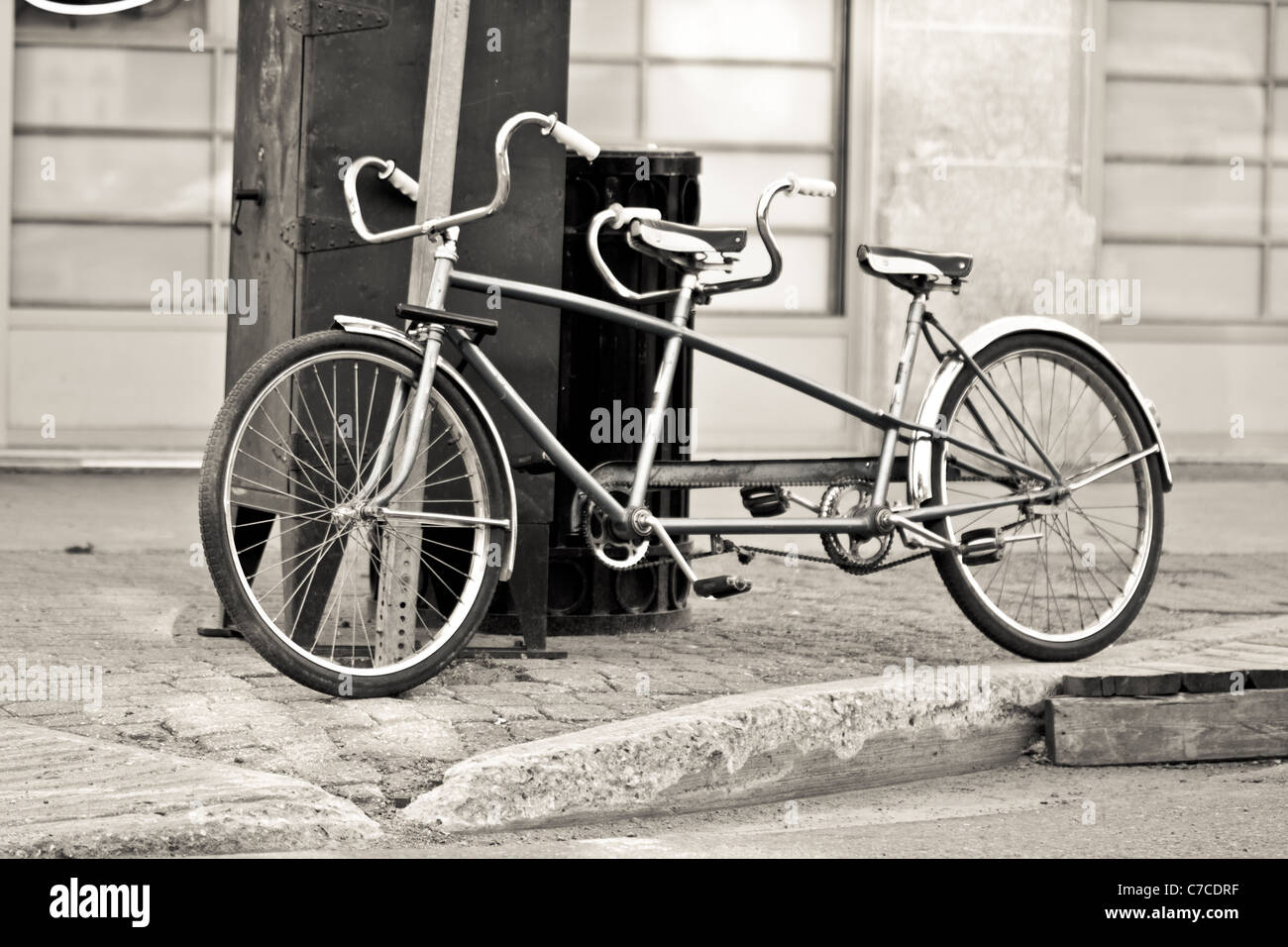 Una vieja bicicleta biplaza estacionados en las calles Fotografía de stock  - Alamy