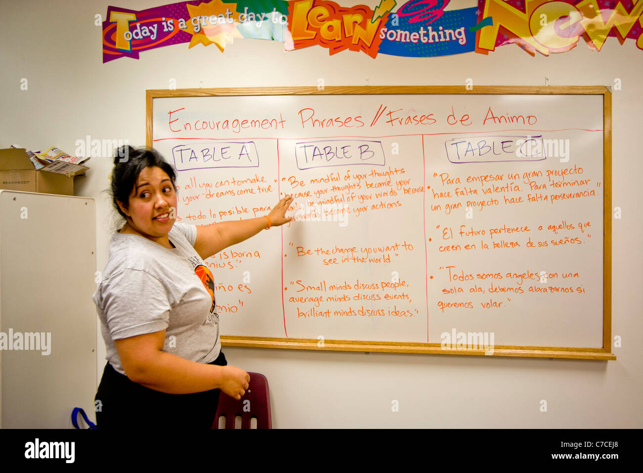 Un hispano elementary school atrae la atención de su clase una lista de frases bilingües de aliento. Foto de stock