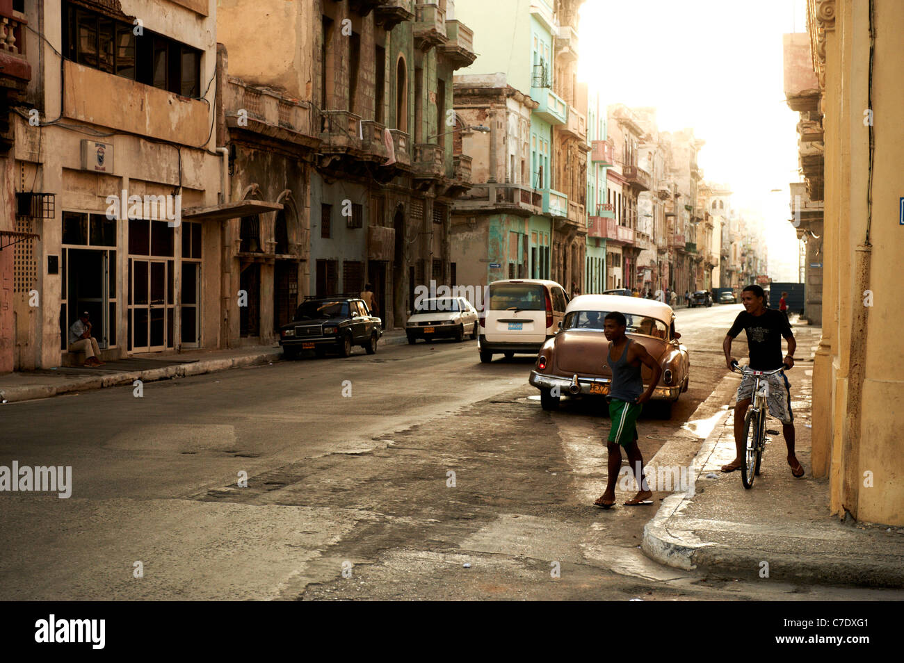 Escena callejera en La Habana, Cuba, coches y bicicletas de hombres Foto de stock