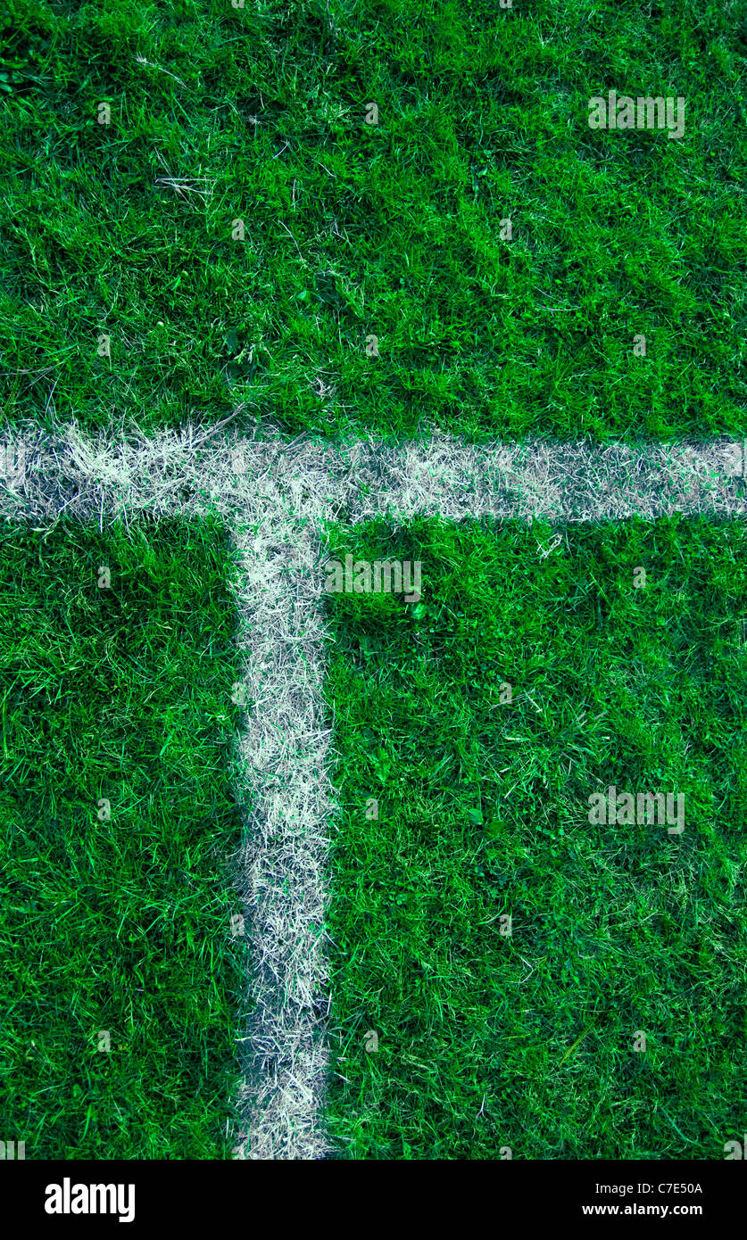 Líneas deportivas pintadas sobre un terreno de juego de hierba verde. Foto de stock