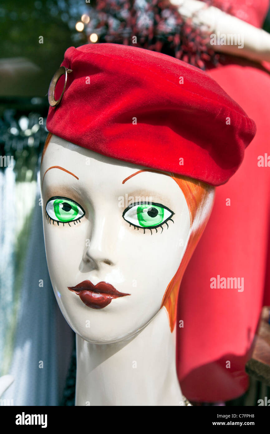 Ojos verdes retro maniqui cabeza con las cejas arqueadas y pouty labios rojos vistiendo hot pink hat de terciopelo en la Plaza Pioneer escaparate Foto de stock