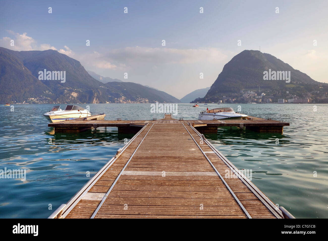 Un impresionante embarcadero en el lago de Lugano, con vistas al Monte Salvatore Foto de stock
