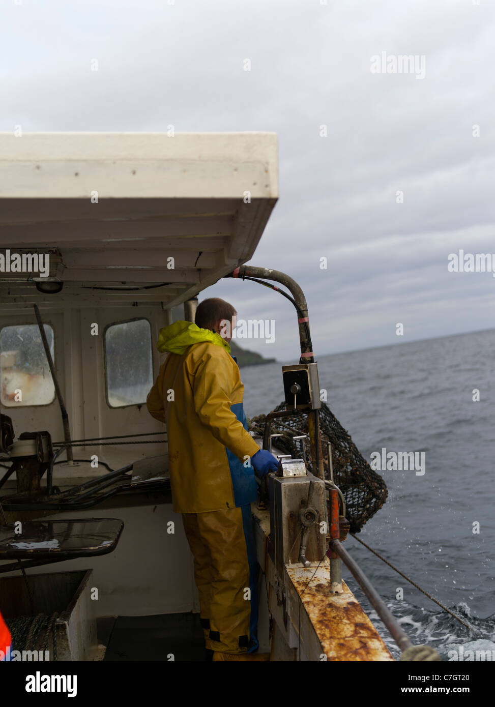 dh PESCA Pescadores DE ORKNEY cargando creel a bordo del barco de pesca olla de langosta pescador ollas de pescado Foto de stock