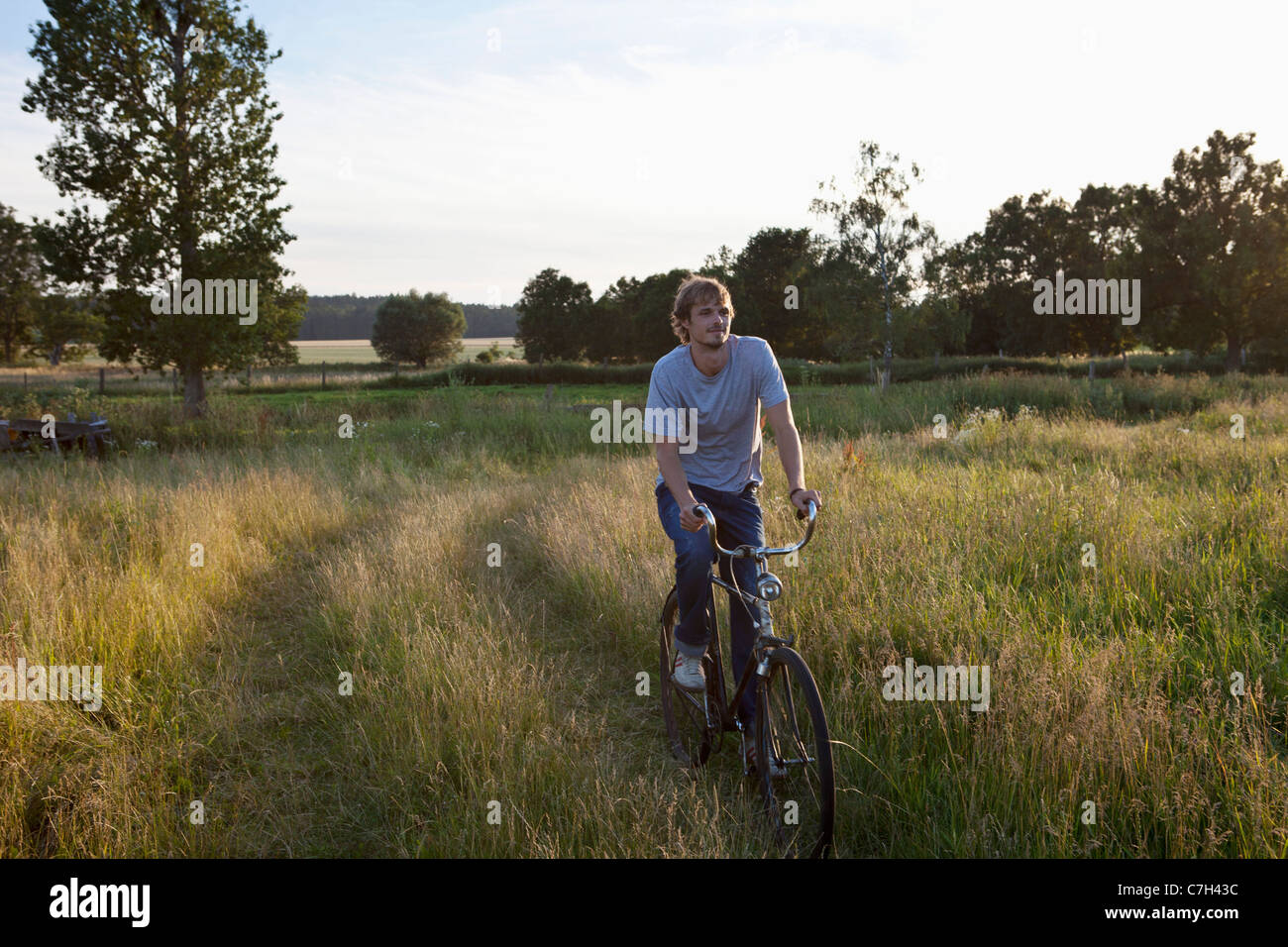 Guy recorre campo apartada en bicicleta Foto de stock