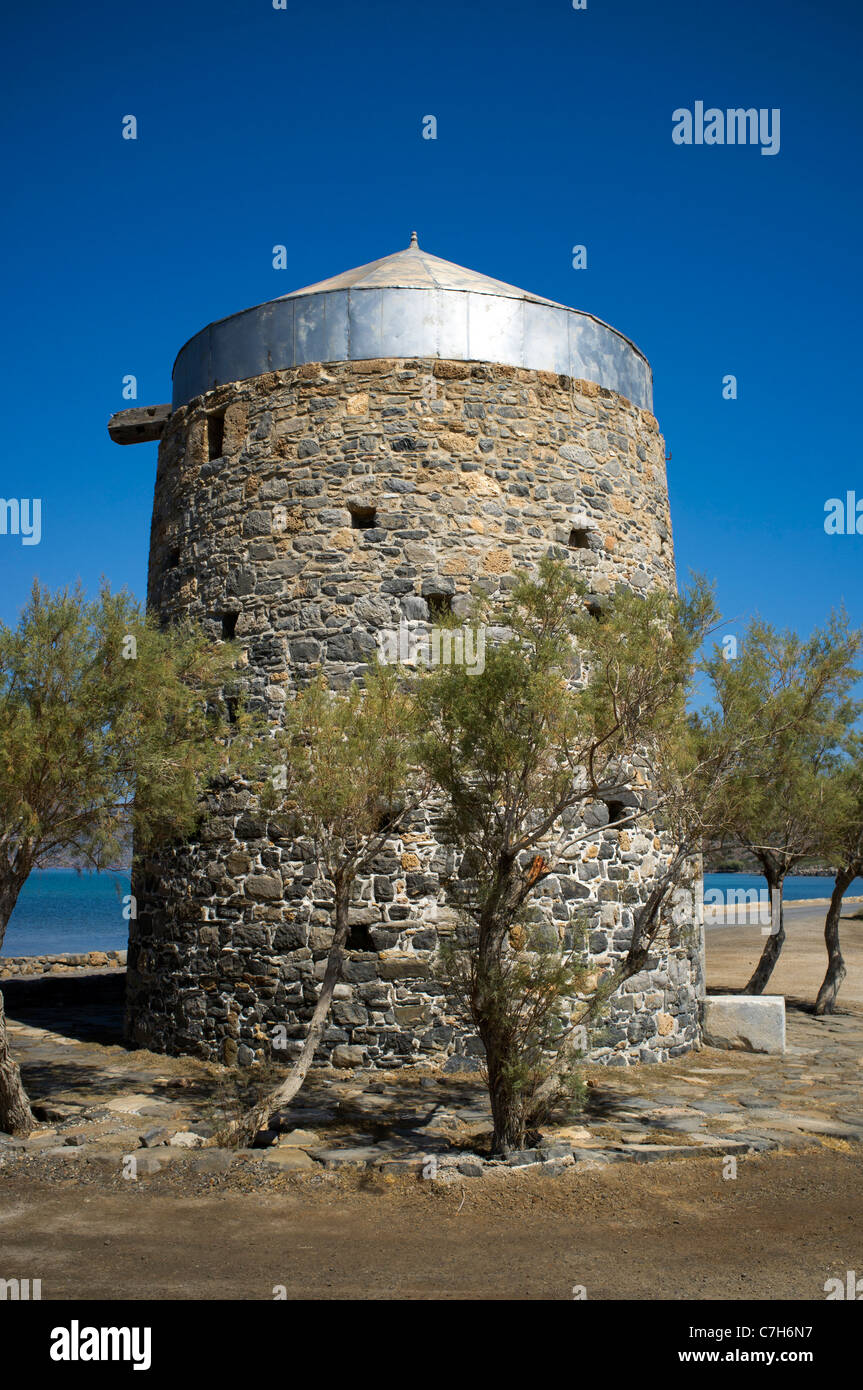 Un molino en desuso rodeada de olivos en la península de Spinalonga, cerca de la localidad de Elounda en Creta Foto de stock