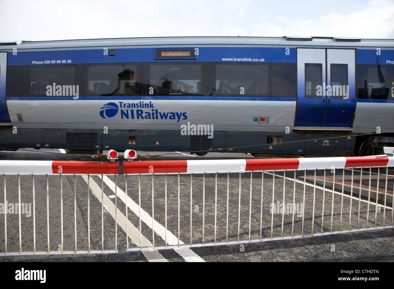 Nivel de tren pasa nir cruzar barreras cerradas castlerock railway station Irlanda del Norte Reino Unido desenfoque de movimiento de acción Foto de stock