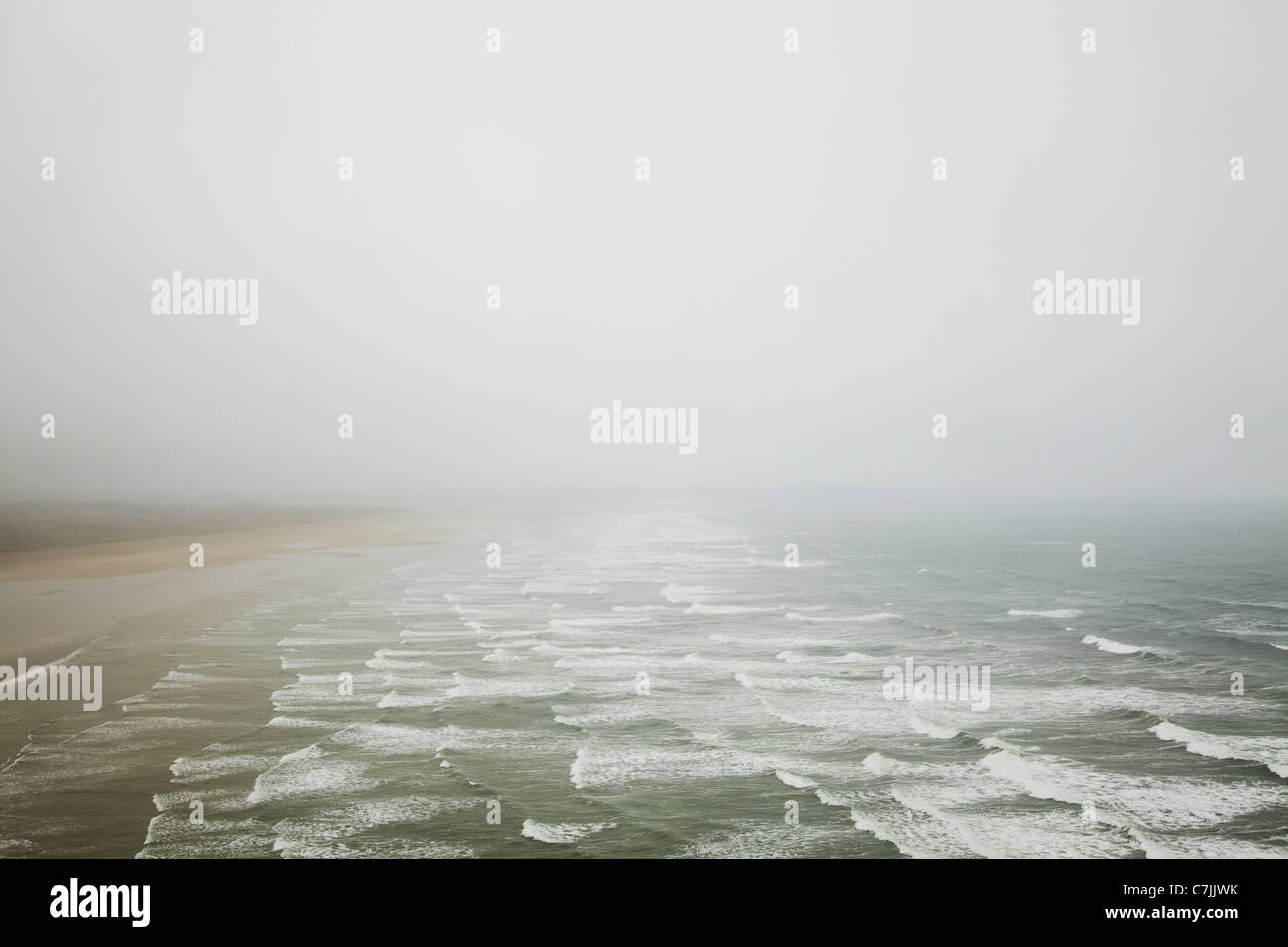Olas rompiendo en la playa de niebla Foto de stock