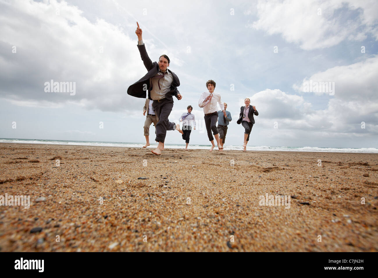 Los empresarios se ejecutan en playa Foto de stock