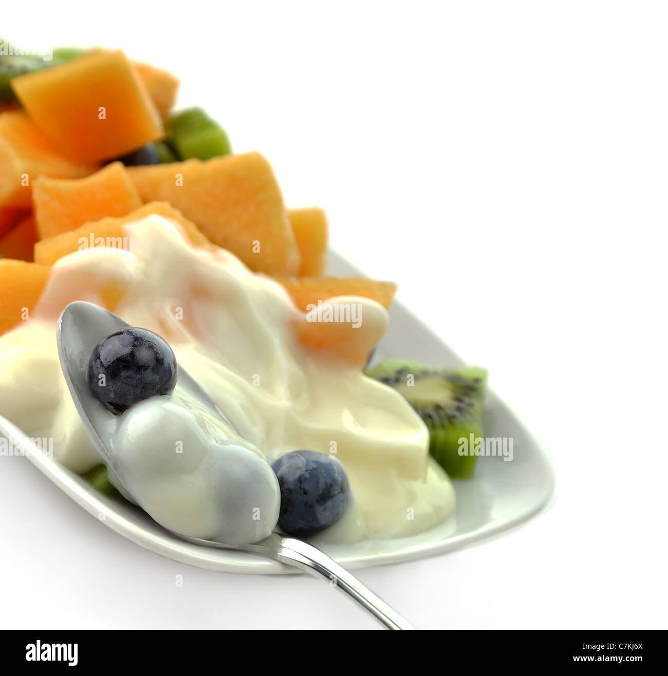 Primer plano de una cuchara con fruta y yogur Foto de stock