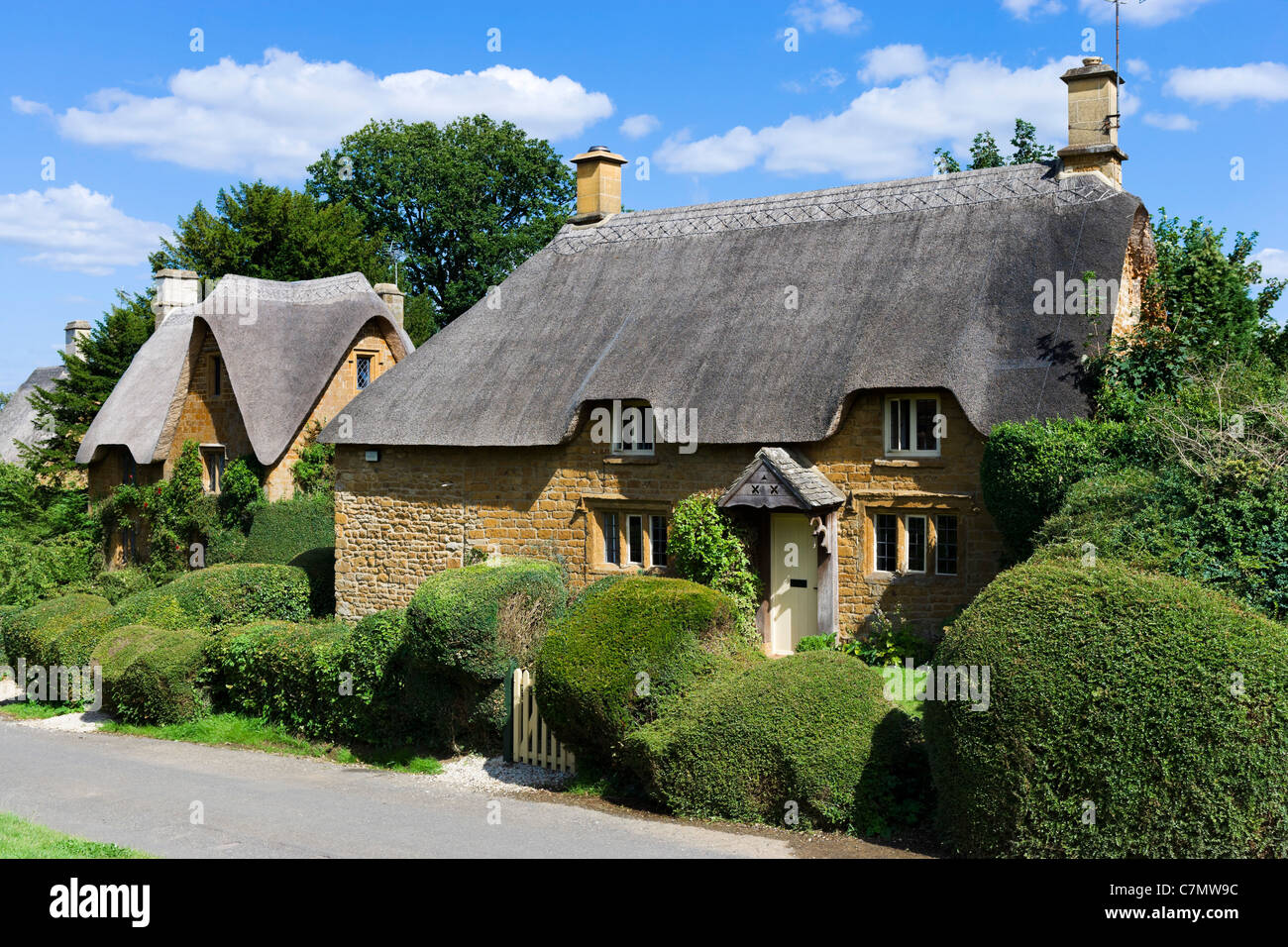Cabañas con techo de paja en la aldea de Cotswold Gran Tew, Oxfordshire, Inglaterra, Reino Unido. Foto de stock