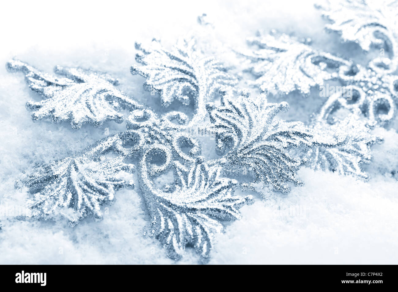 Brillantes adornos de Navidad con nieve. Clave alta macro de tonos azules con muy poca profundidad DOF. Foto de stock