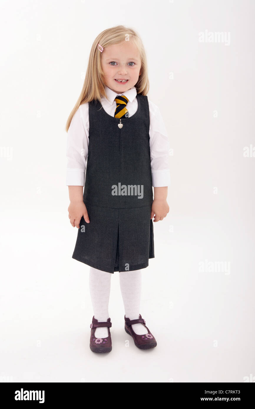 Cinco años de edad, niña de pie en su nuevo uniforme escolar. Foto de stock