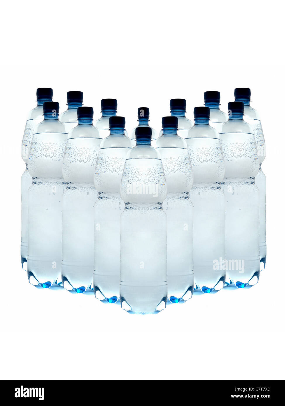 Las botellas de plástico de agua mineral, dispuestas en fila sobre un fondo blanco. Foto de stock