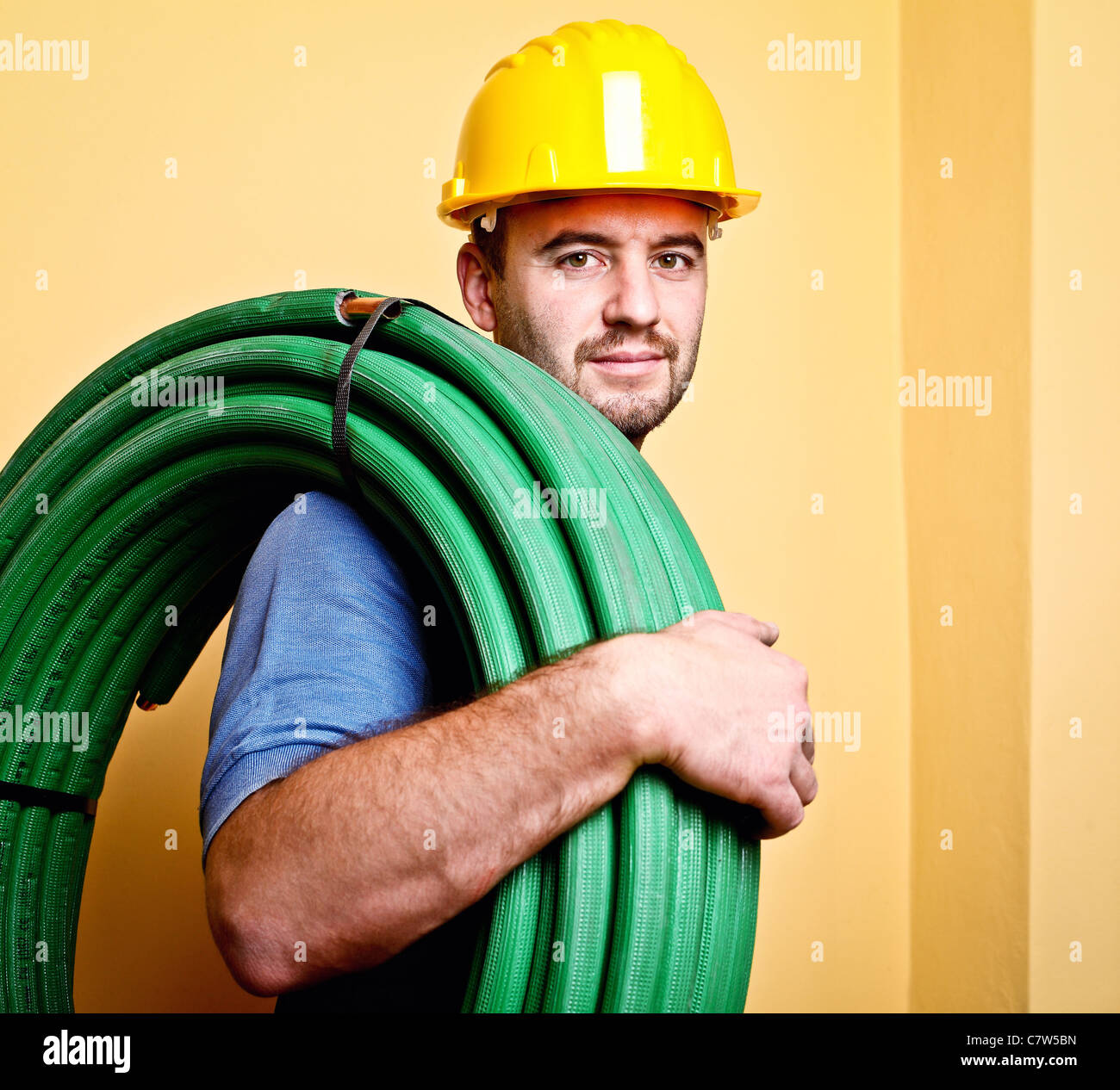 Retrato de caucásico trabajador manual con tubo Foto de stock