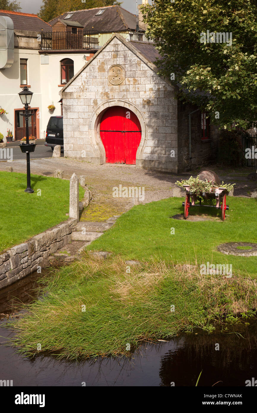 Irlanda, Co Wicklow, Aughrim, arco con forma de herradura, con puertas pintadas de rojo para forja junto al río Foto de stock