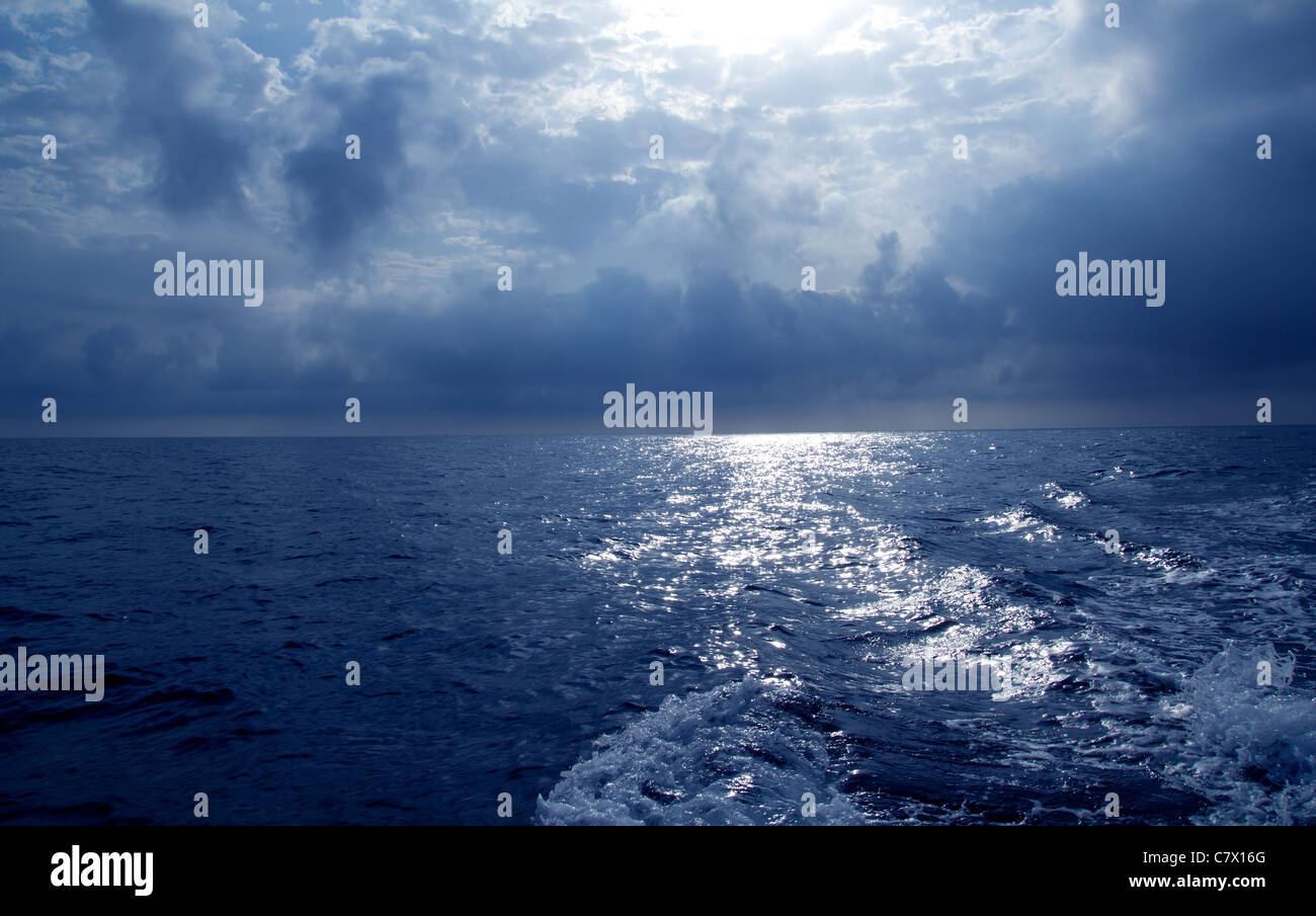 Mar azul en tormentoso cielo espectacular día con barco wake Foto de stock