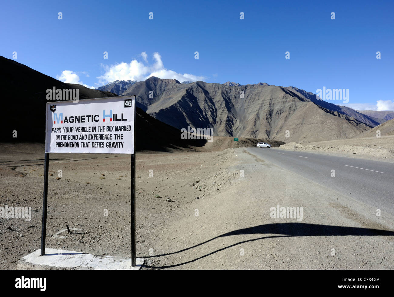 Signo de Magnetic Hill en la carretera de Leh a Kargil que pretende desafiar a la gravedad. Cerca de Nimu, Ladakh, República de la India. Foto de stock