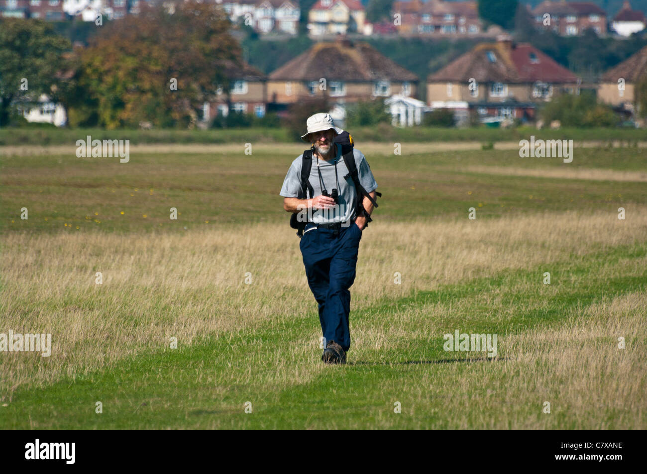 Twitcher ornitólogo Rambler Walker con llevar binoculares caminando Foto de stock