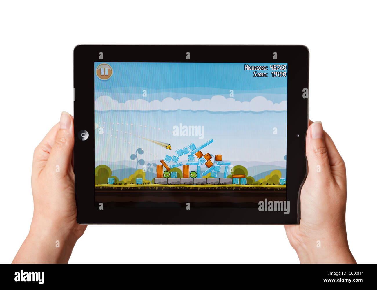 Manos sosteniendo un iPad jugando el juego Angry Birds Foto de stock