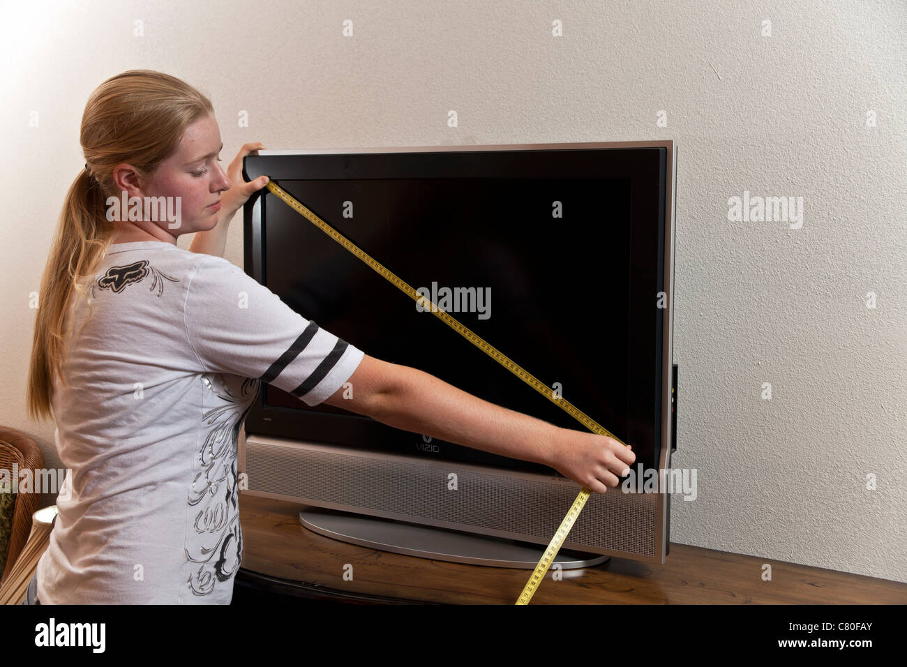 Adolescente mide las dimensiones de una pantalla de televisión de 80  centímetros. Señor © Myrleen Pearson Fotografía de stock - Alamy