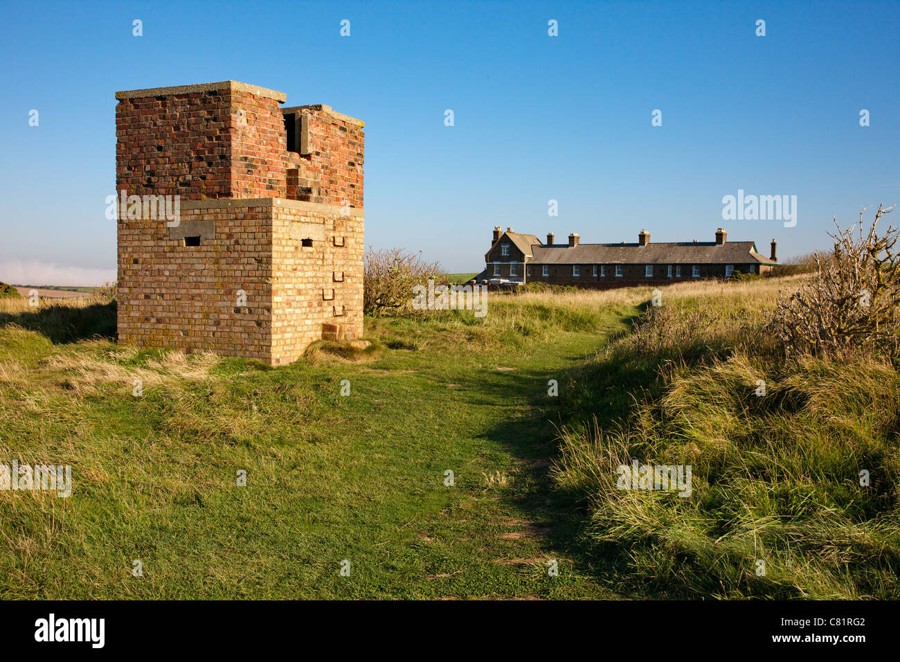 Cabañas Whitenothe y ruinas de edificios de guerra sobre blanco en la costa de Dorset Nothe Foto de stock