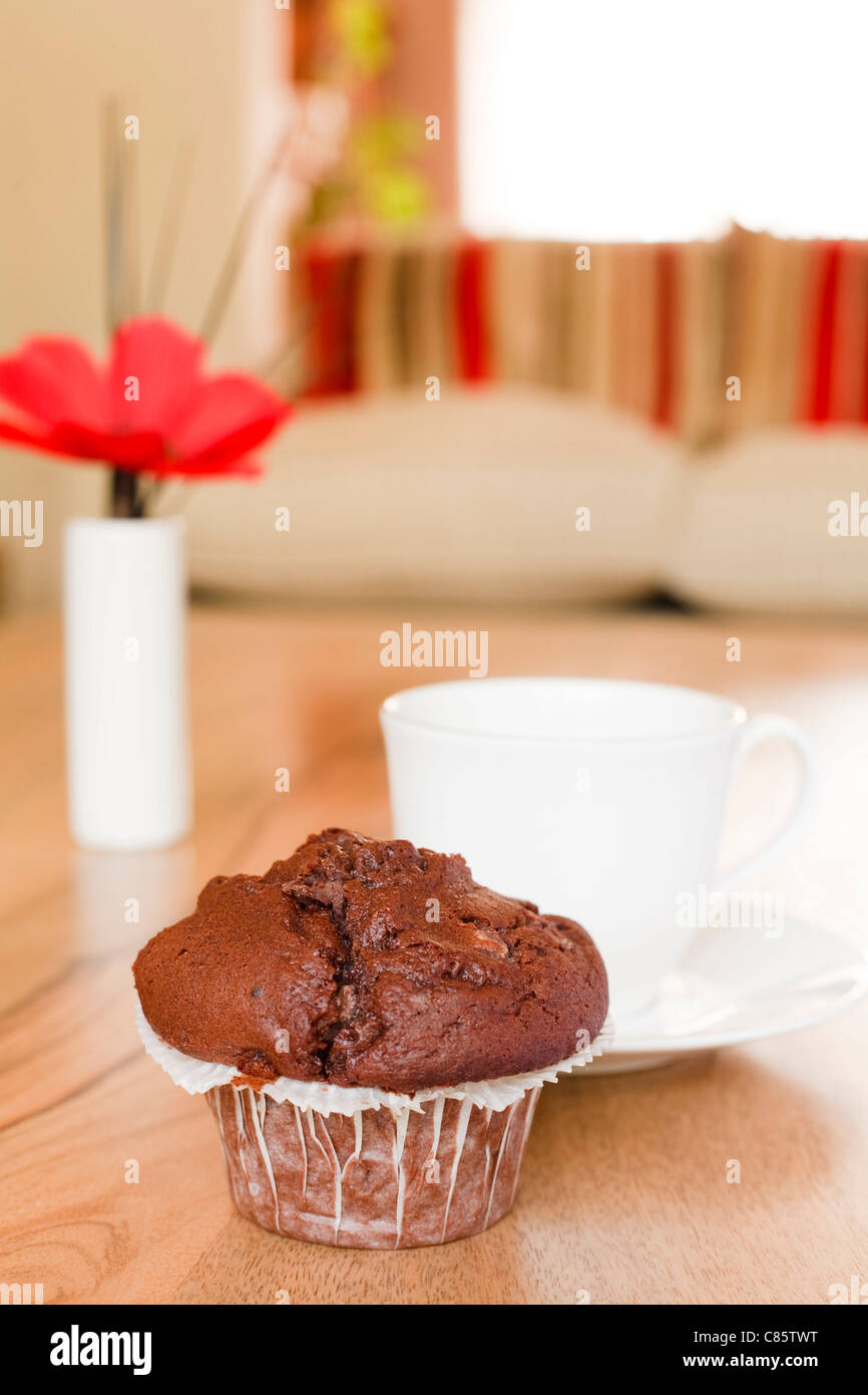 Muffin de chocolate en una mesa de café en una lujosa decoración interior Foto de stock