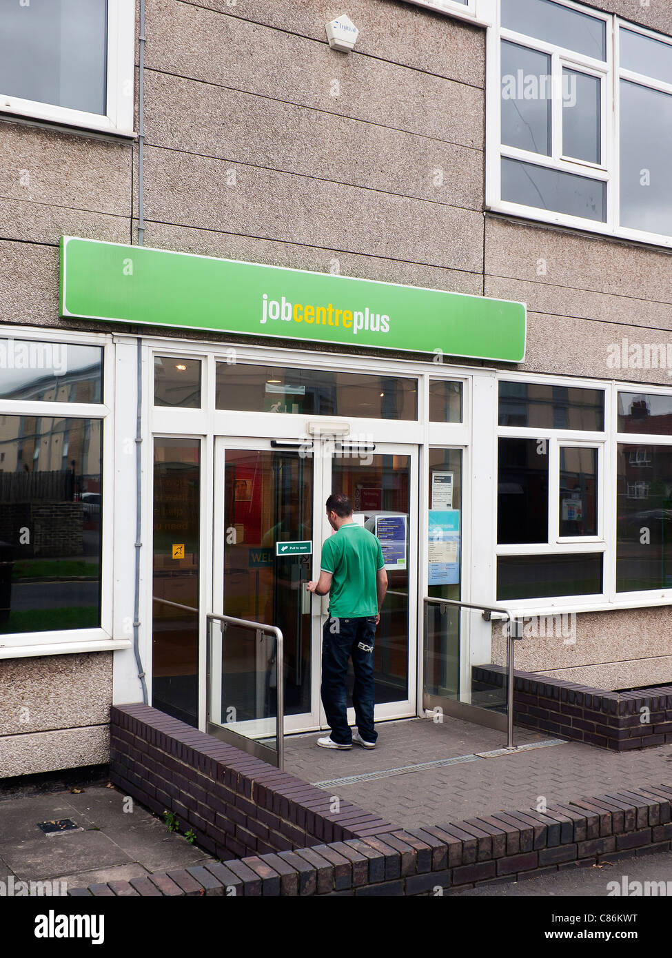 Un hombre va en un Job Centre Plus Gobierno Bolsa de empleo para los solicitantes de empleo Northallerton North Yorkshire, Reino Unido Foto de stock