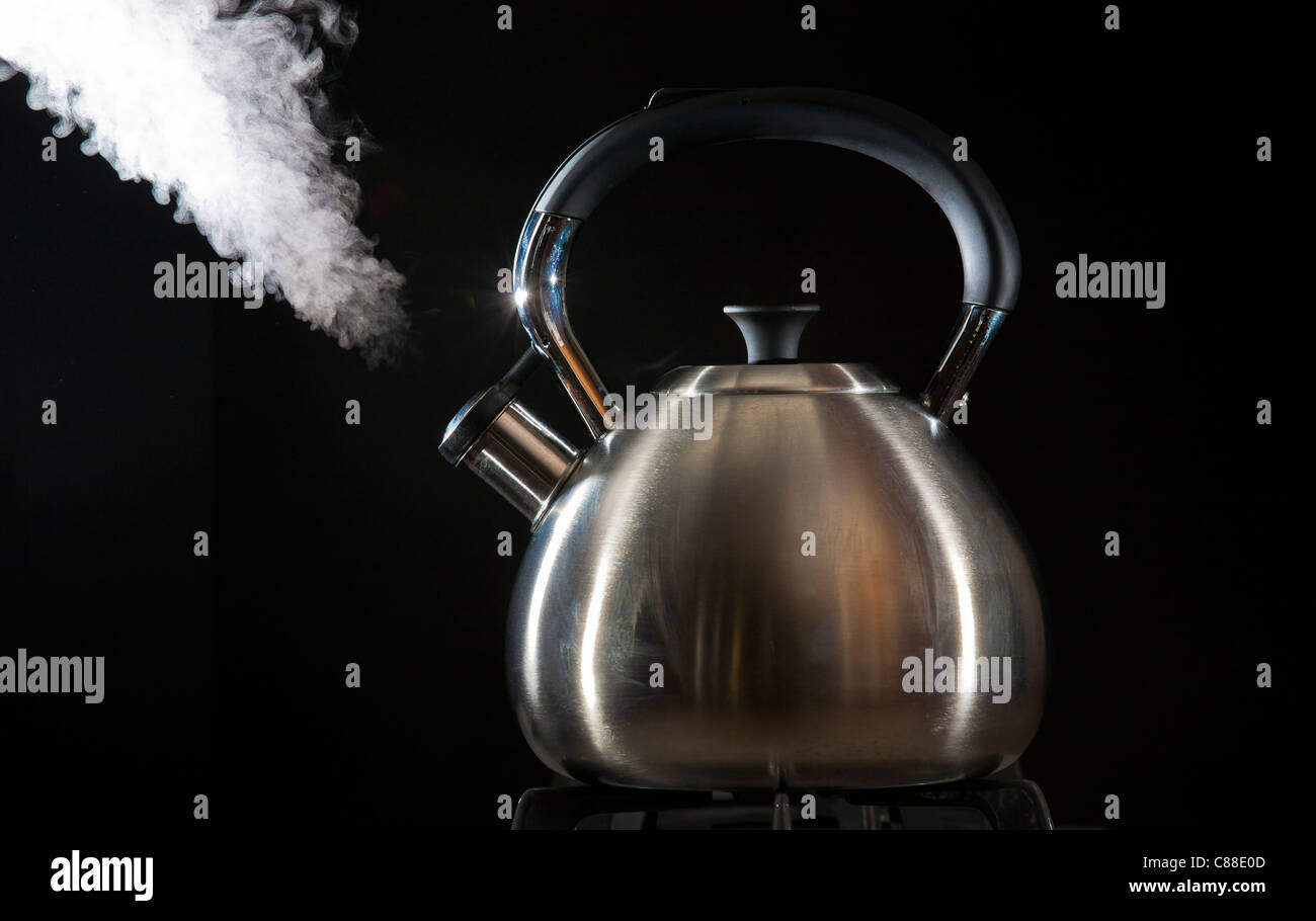 Tetera de agua caliente en la estufa y silbido de vapor Fotografía de stock  - Alamy
