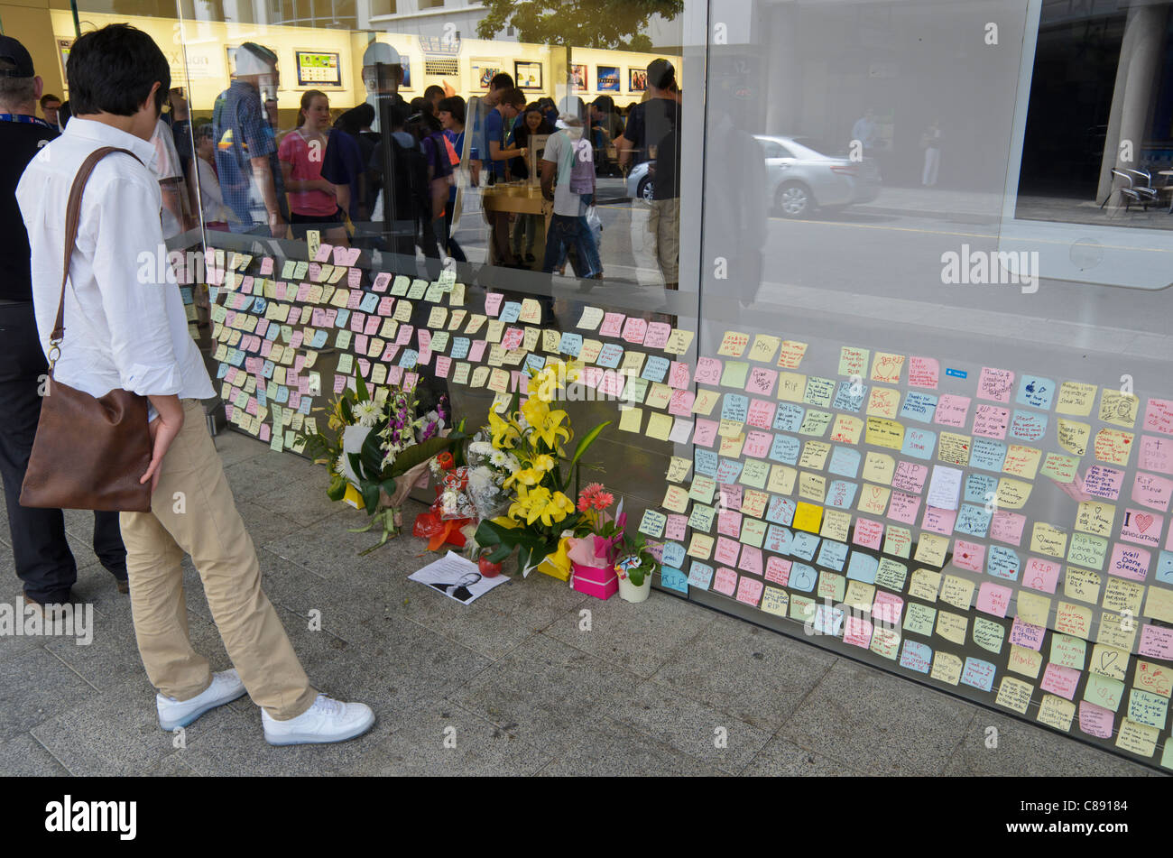 Un hombre mira la nota post-it homenajes en el escaparate de una tienda de Apple en Perth, Australia Occidental Foto de stock