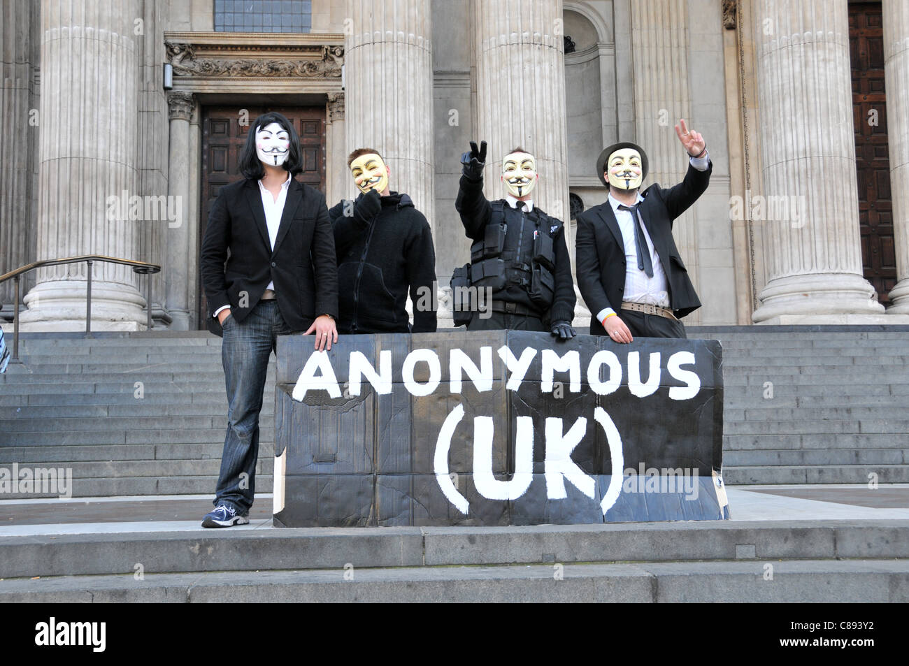 Anonymous UK manifestantes portando máscaras de Guy Fawkes Anti capitalistas crear una ciudad de carpas en el Patio de san Pablo, cerca de la Bolsa de Valores de Londres en el segundo día de ocupar Londres. Domingo 16 de octubre de 2011 Foto de stock
