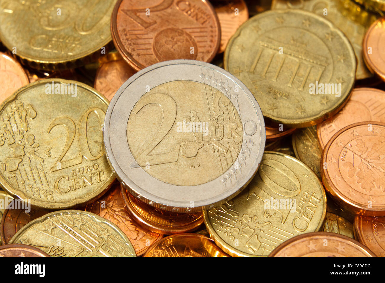 Una moneda de dos euros se encuentra cerca del centro de un montón de otros  actuales, modernas, las monedas de euro Fotografía de stock - Alamy