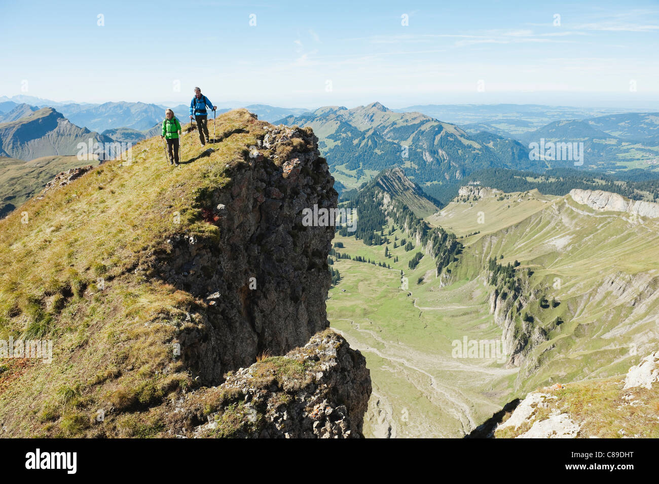Austria, Kleinwalsertal, hombre y mujer, caminatas por el borde del acantilado Foto de stock