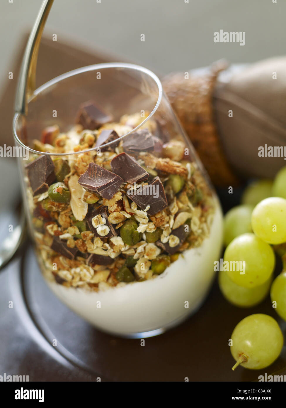 El yogurt con cereales, frutos secos y chips de chocolate Foto de stock