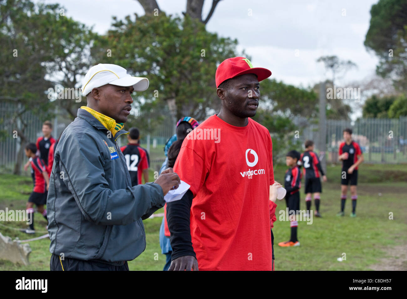 Los entrenadores de fútbol viendo un partido de un equipo juvenil en Cape Town South Africa Foto de stock