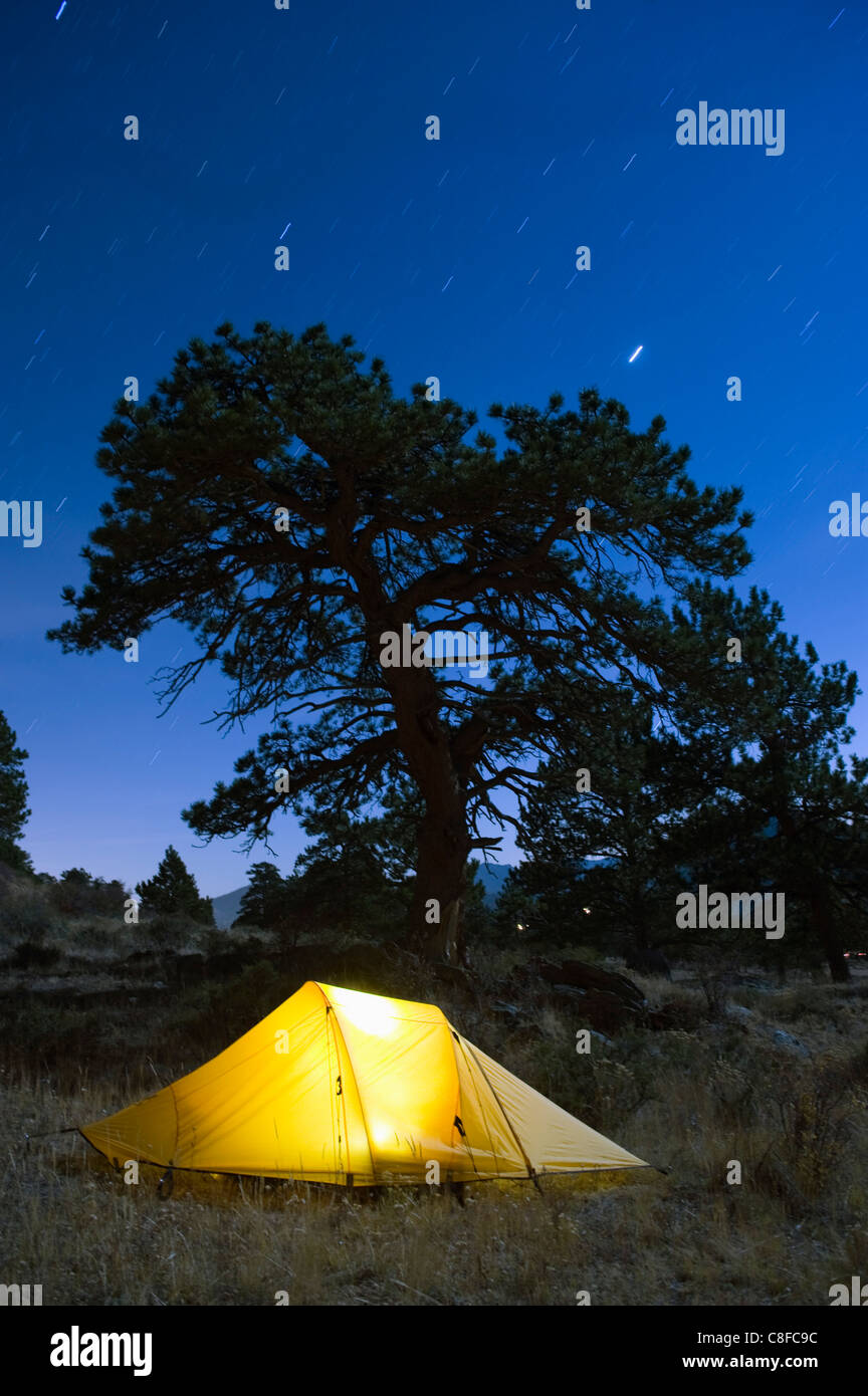 Tienda iluminados bajo el cielo nocturno, el Parque Nacional de Rocky Mountain, Colorado, Estados Unidos de América Foto de stock