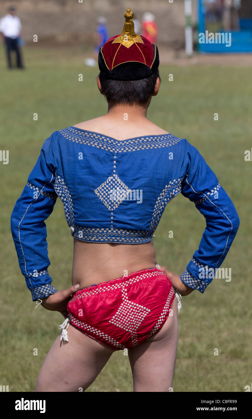 Vestida con un traje tradicional a un joven luchador espera combatir en la lucha en el Naadam Tsetserleg. Foto de stock