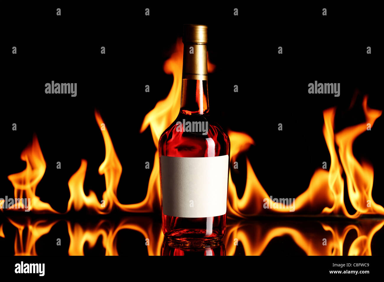 Botella de vino brandy con llamas en el fondo Foto de stock