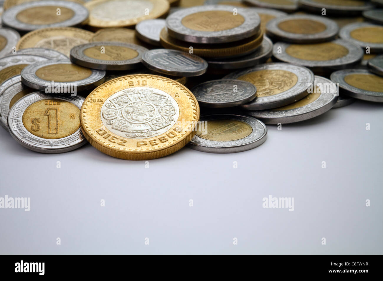 Una moneda de 10 Pesos Mexicanos iluminada entre un montón de otras  modernas Peso Mexicano Dólar y céntimos Fotografía de stock - Alamy