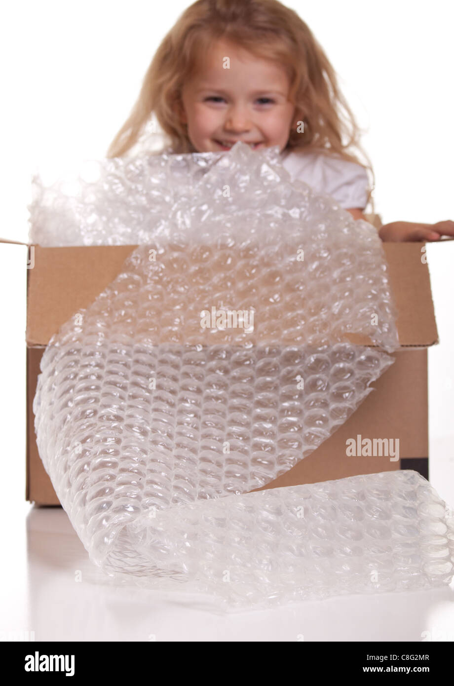 Una excelente imagen de un lindo niño se empaquetan en una caja de envío. Foto de stock