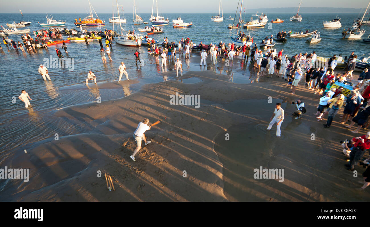 Las zarzas cricket inglés excéntrico partido jugado en medio de un banco de arena en el Solent en primavera de marea baja por diversión Foto de stock