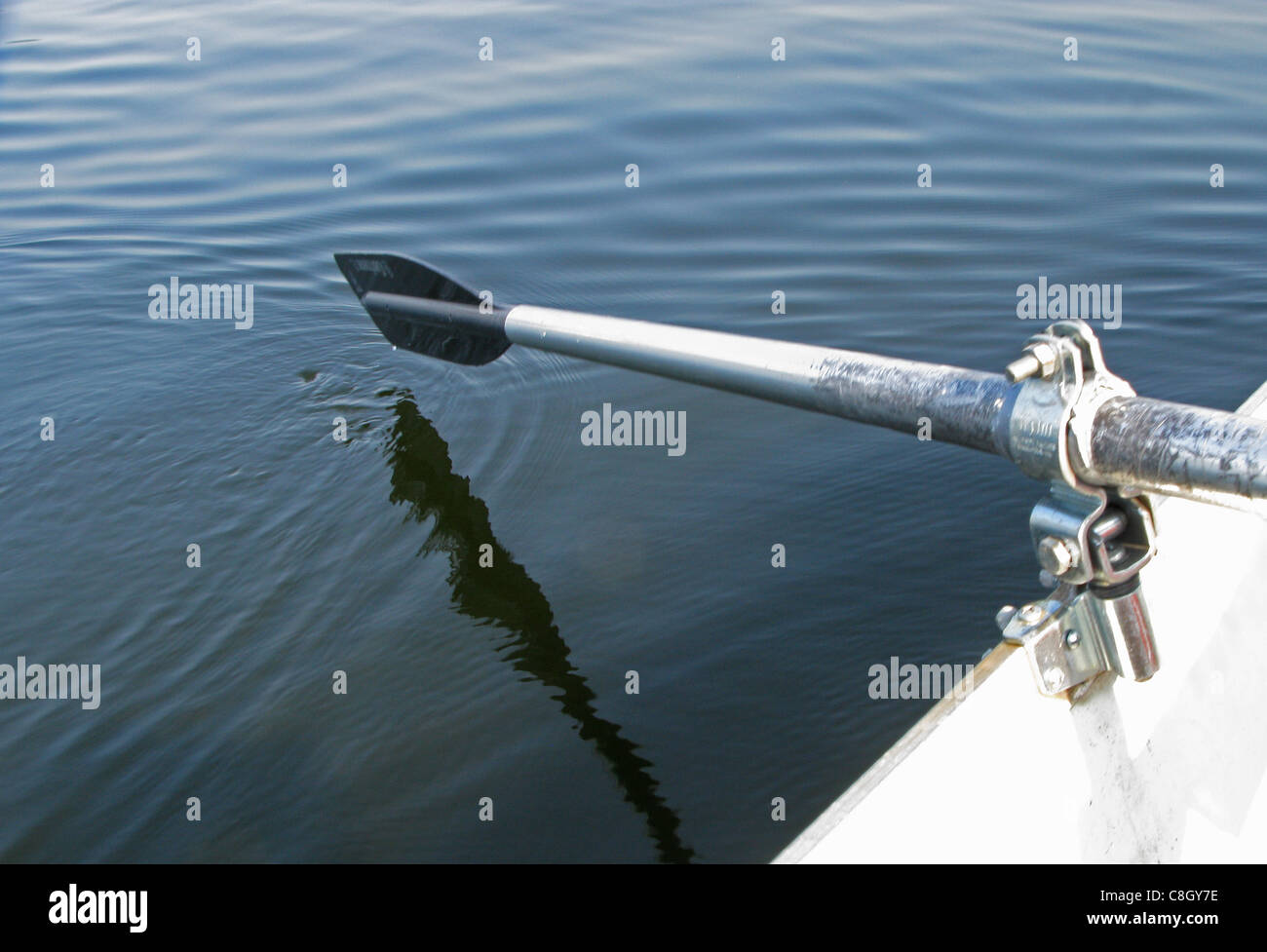 Un remo de un bote de remos ligeramente por encima de la superficie del agua. Foto de stock