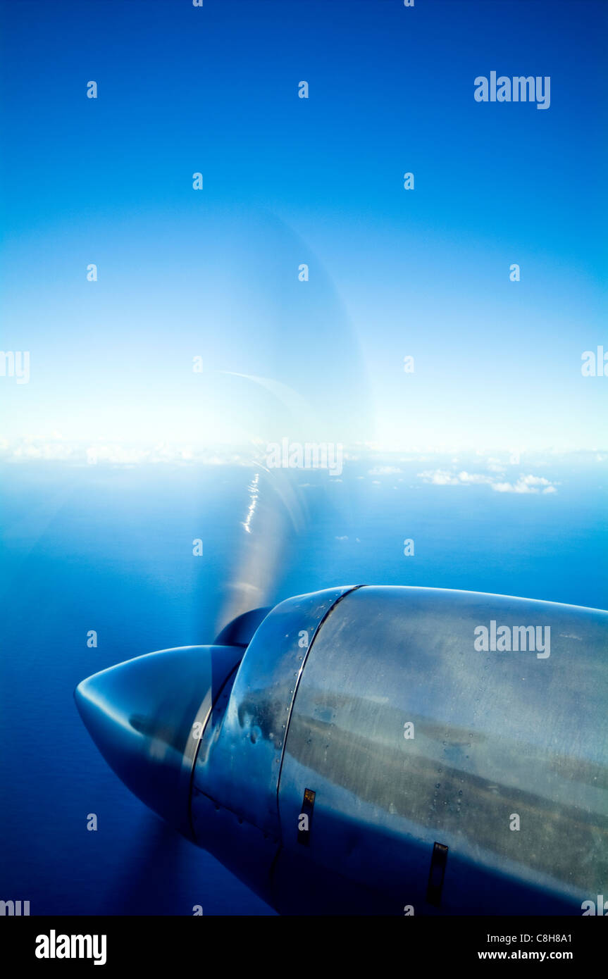 Cromado motor y hélice de un avión sobrevolando las islas tropicales. Foto de stock
