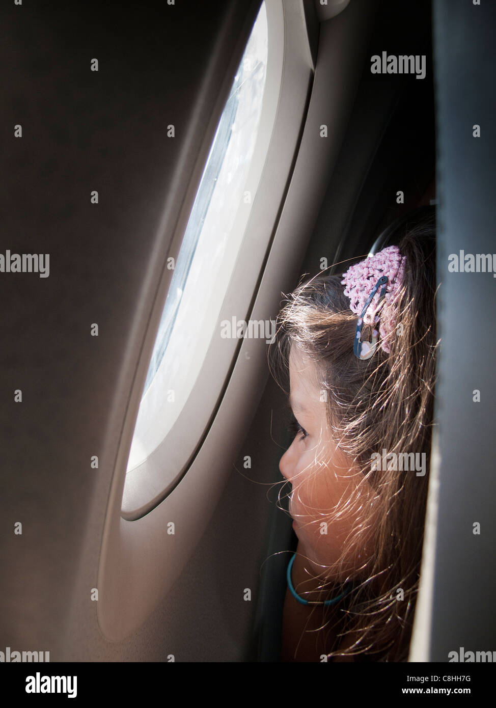Niño mirando por la ventana en un avión Foto de stock