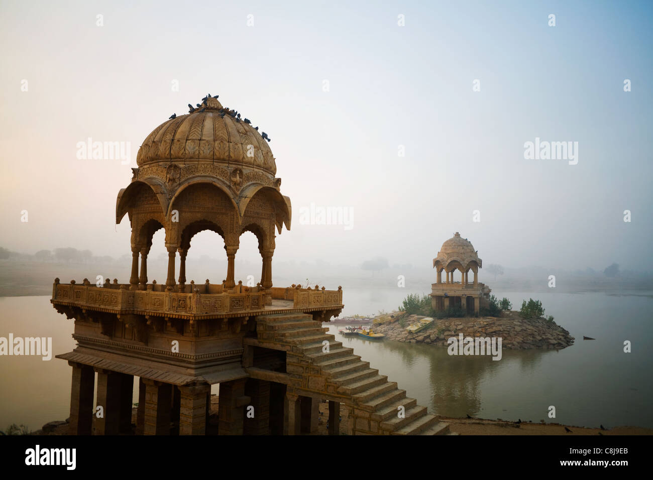Los pabellones y la niebla en el amanecer en el siglo XIV el hombre Lago Gadisar, Jaisalmer, Rajasthan, India Foto de stock