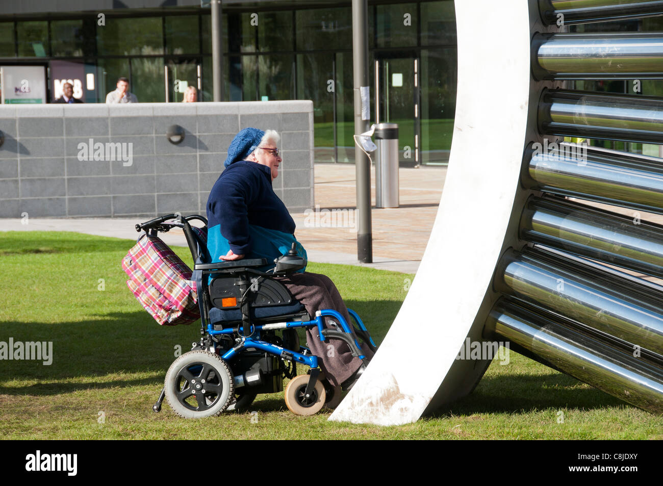 Mujer en una silla de ruedas mirando la escultura por Luke Jerram Aeolus en MediaCityUK, Salford, Manchester, Inglaterra, Reino Unido. Foto de stock