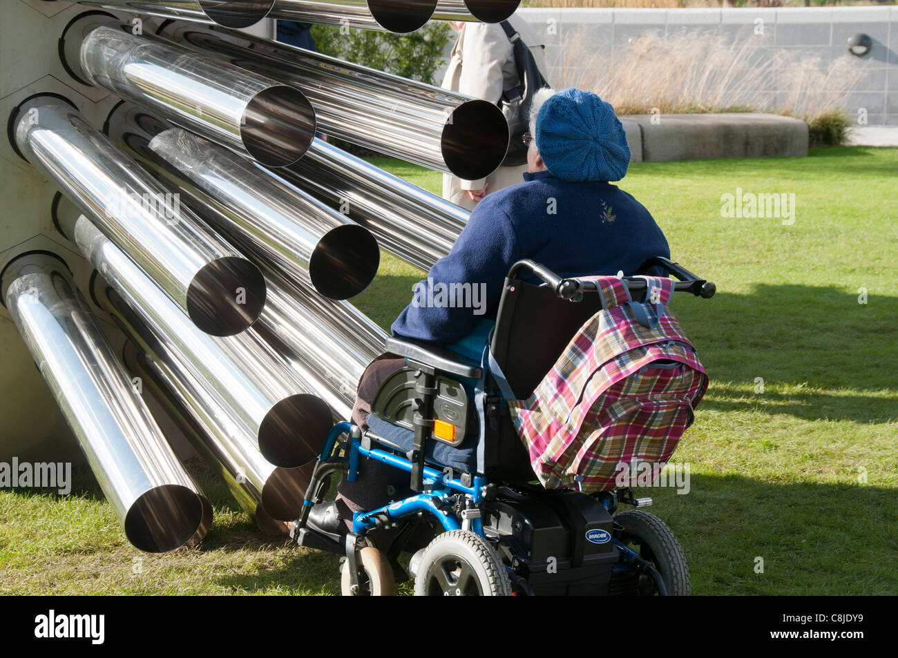 Mujer en una silla de ruedas mirando la escultura por Luke Jerram Aeolus en MediaCityUK, Salford, Manchester, Inglaterra, Reino Unido. Foto de stock