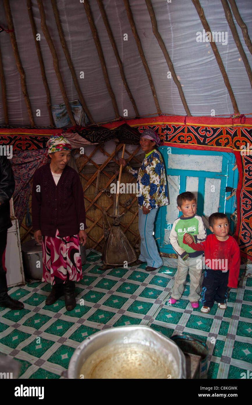Interior de ger en Mongolia. La familia es batido de leche de yegua en una base para crear airag fermentado. Foto de stock