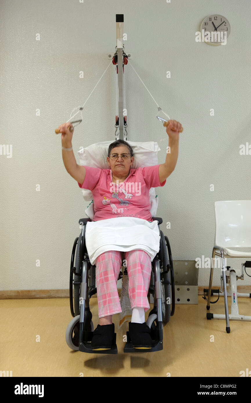 Mujer en silla de ruedas haciendo ejercicios de rehabilitación física en el  gimnasio de fisioterapia del hospital Fotografía de stock - Alamy